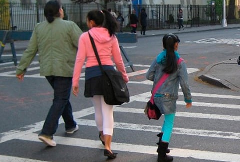Children walking in a crosswalk on their way to school in New York City.