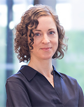 Woman wearing a dark blue collared shirt indoors