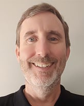 Smiling man in a dark shirt indoors