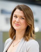 Woman wearing a light gray suit in an office setting