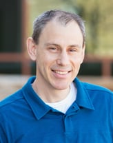 Robert Wildey smiling in a blue polo shirt.