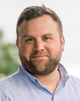 Bearded man wearing a light blue button down shirt