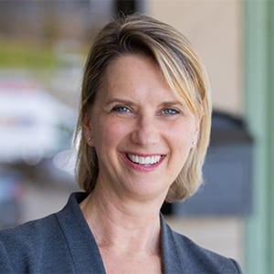 Meredith Avery smiling in a Dark gray blazer.