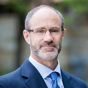 Tim Upton in a suit and tie in an outdoor setting