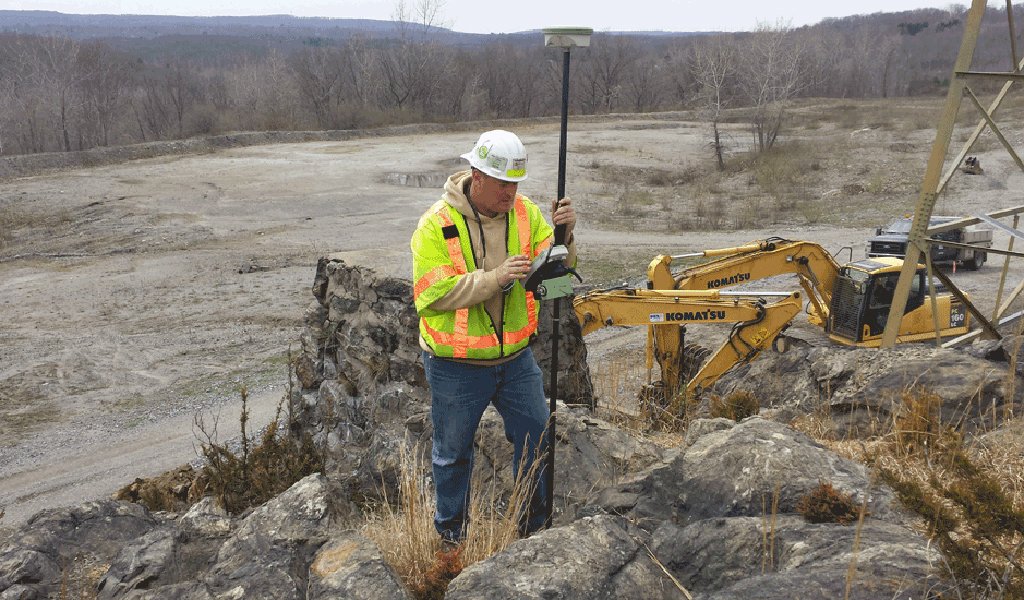 Land surveyor in the field for utility project.