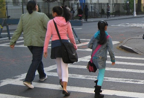 Children walking in a crosswalk on their way to school in New York City.