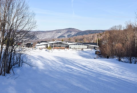 Killington old lodge surrounded by snow mountains.