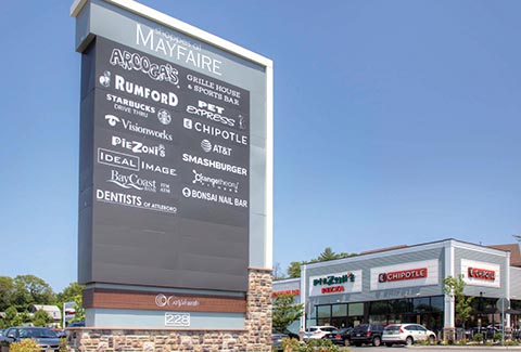 Entryway sign showing a list of businesses at the Shoppes at Wayfair in Attleboro, Massachusetts.