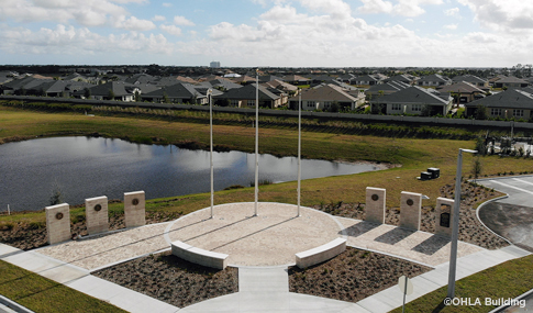 Three stone monuments in front of a Veterans nursing home that have plaques honoring Veterans.