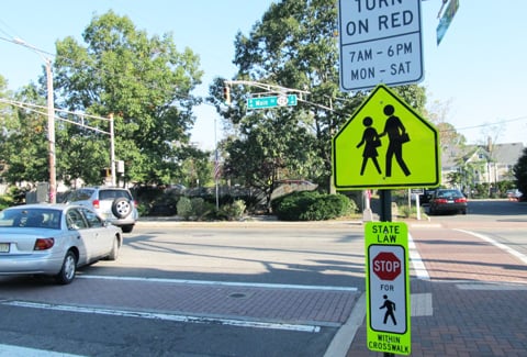 A traffic sign to promote pedestrian safety at an intersection.