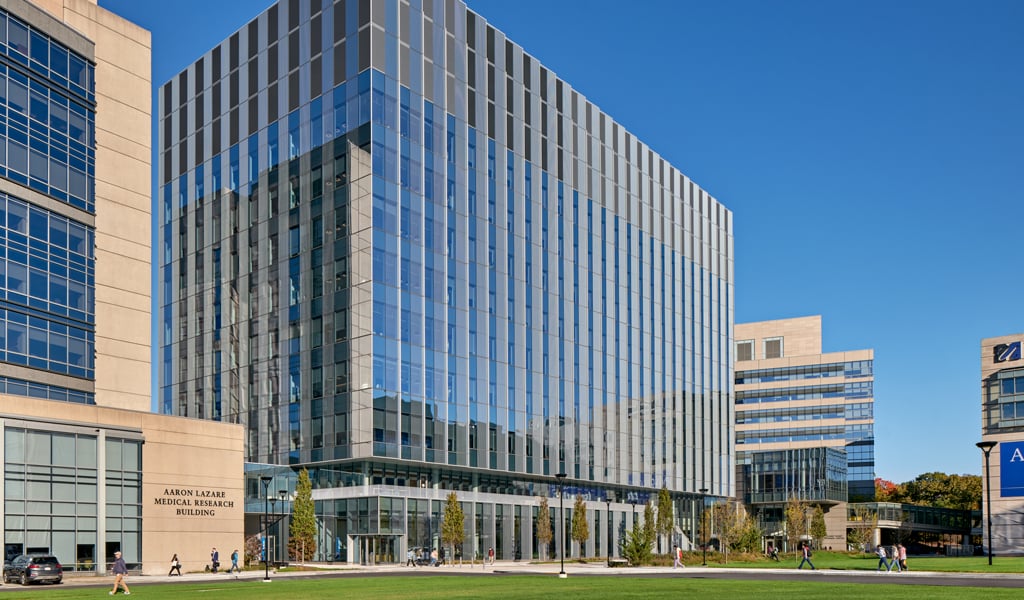 A large modern glass building flanked by a grass quad.