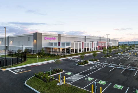 A Wayfair logistics center with parking lot featuring EV charging stations.
