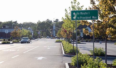 Roads in a parking lot lead out of a shopping center.