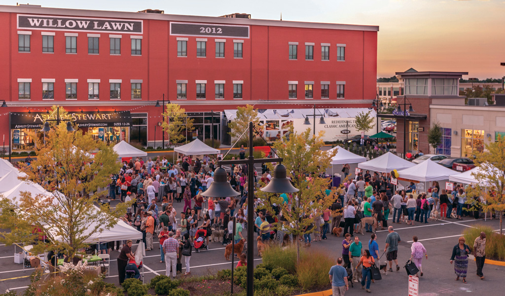 Looking down on a crowd of people enjoying a festival in the parking lot at Willow Lawn.