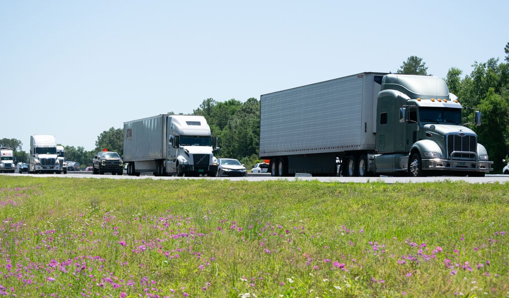 Semi-trucks traveling down an interstate.