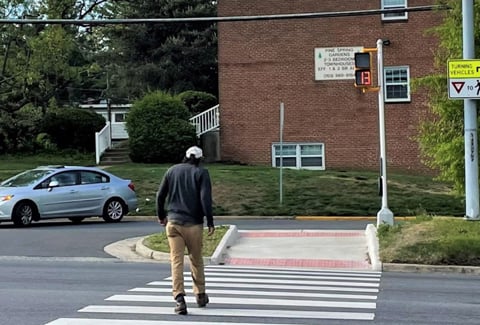 A signalized intersection with new crosswalk, pedestrian refuge and signal.