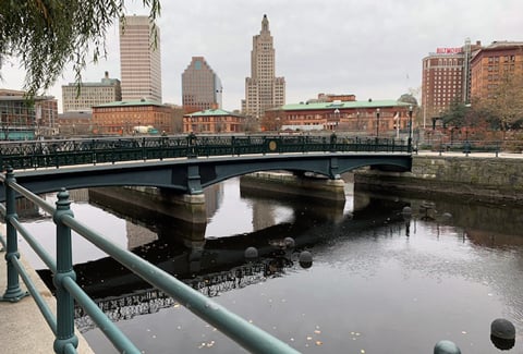 A bridge over a river in downtown Providence with city buildings in background.