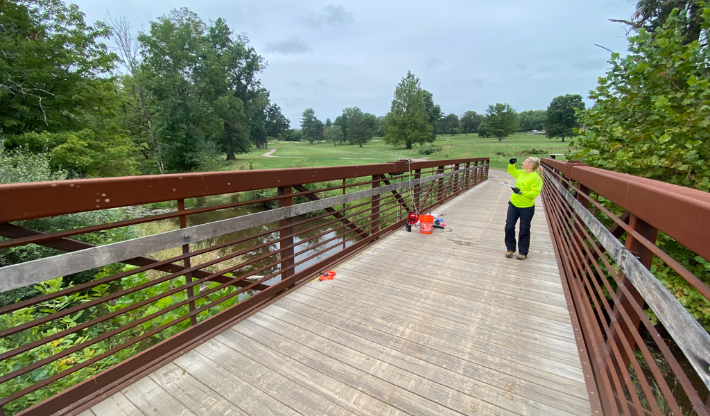 VHB employee in neon shirt monitoring water quality on the golf course.