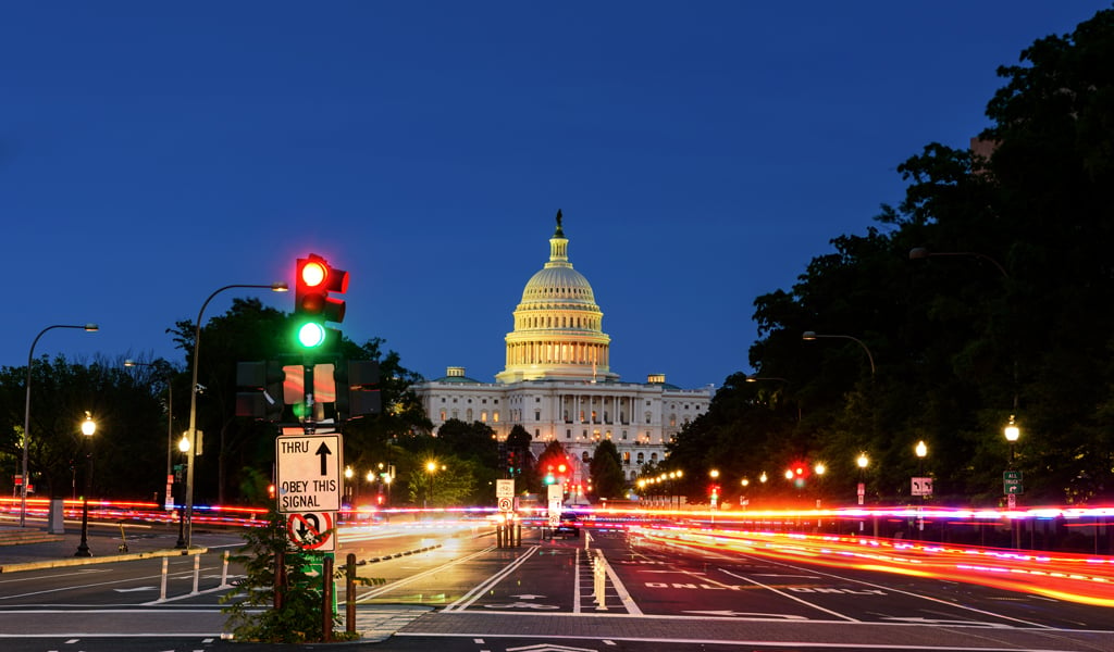 Nighttime view of U.S. Capitol with streetlights.