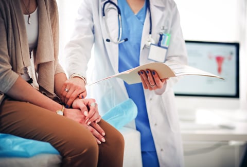 Doctor and patient discussing something in an exam room.