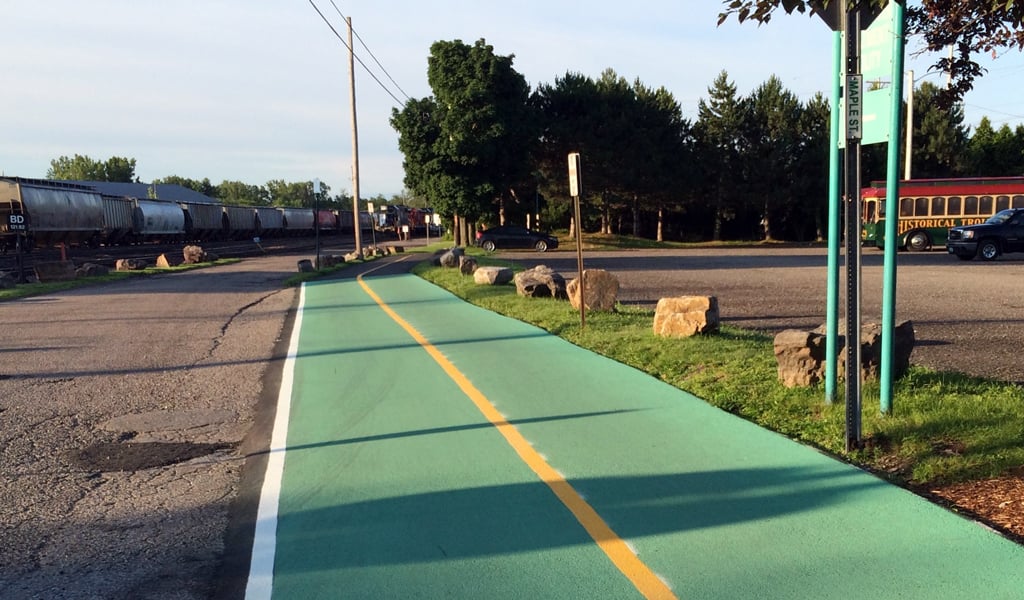 Multi-use path painted green with yellow stripe down the center of the path.