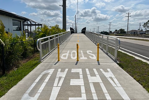 Painted letters indicating Stop Ahead on a multimodal trail path.