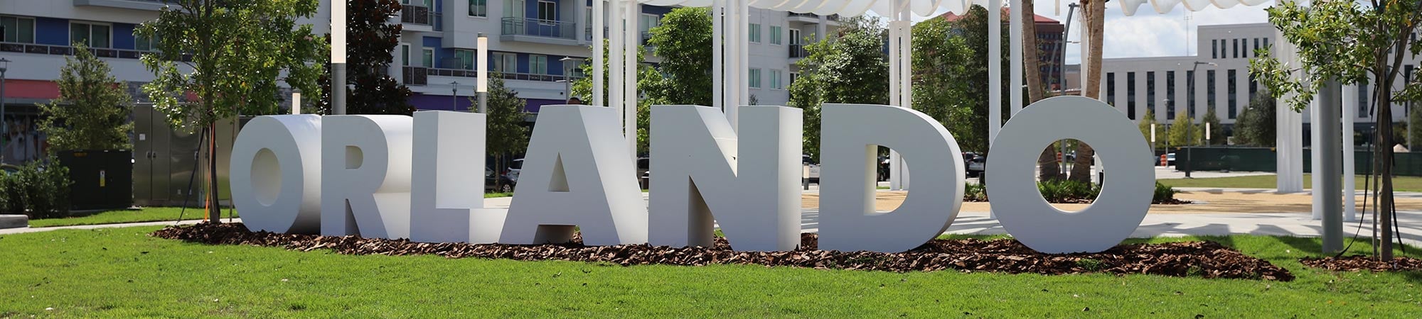 An urban park with a sculpture of the word Orlando