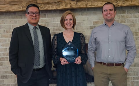 Kara Peach holds the award with Eric Tang and Ian Hamilton.