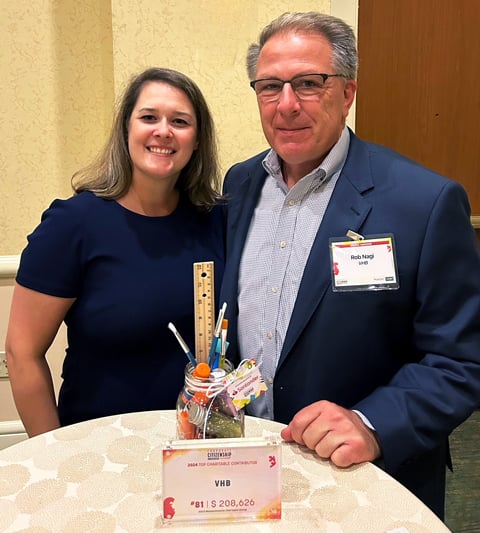 Rob Nagi and Brianne Belschner wearing business attire stand together at the awards ceremony.