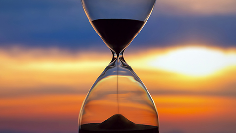 Image of hourglass with sunset backdrop