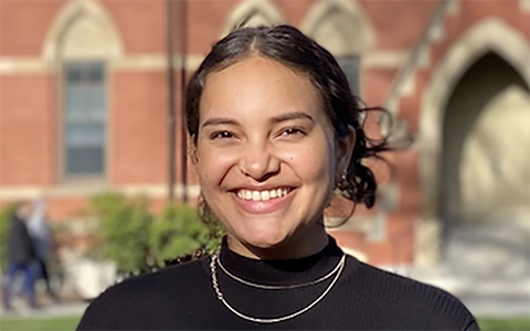 Isabella Buford smiling outside, dressed in a black shirt, highlighting her participation in Tufts REPP program.