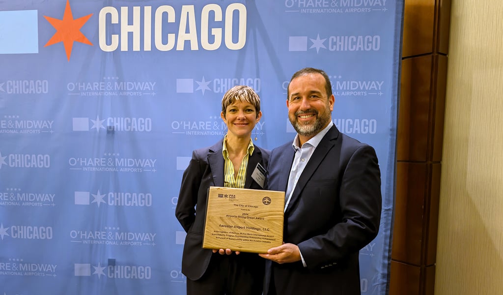 Two people holding an award