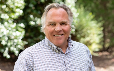 Neville Reynolds stands outside smiling at the camera.