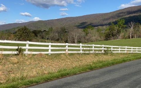 A mountain view with a white fence in Albemarle County, Virginia.