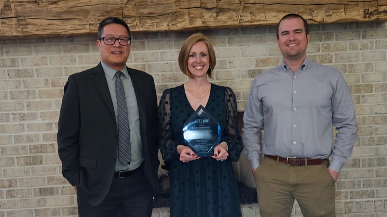 Kara Peach holds the award with Eric Tang and Ian Hamilton.