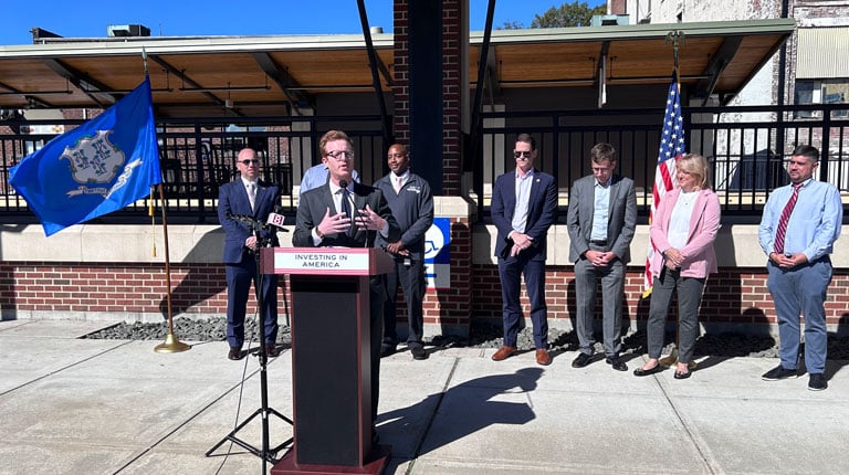 USDOT representative speaking at podium at CTDOT Unified Mobility App launch.