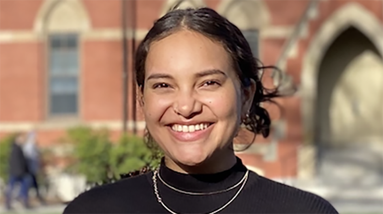 Isabella Buford smiling outside, dressed in a black shirt, highlighting her participation in Tufts REPP program