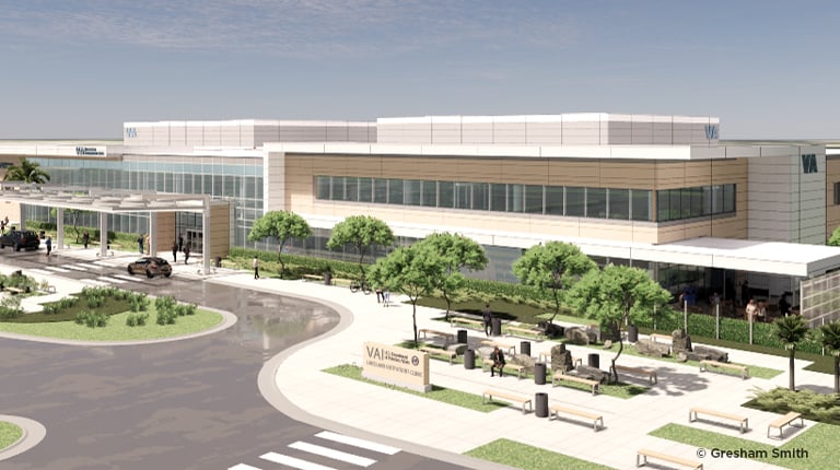 A color rendering of a modern two-story healthcare clinic with people entering and exiting by a flagpole and crosswalk. 