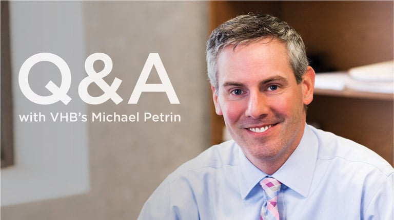 Headshot of Michael Petrin wearing business clothing and smiling with an office background. 