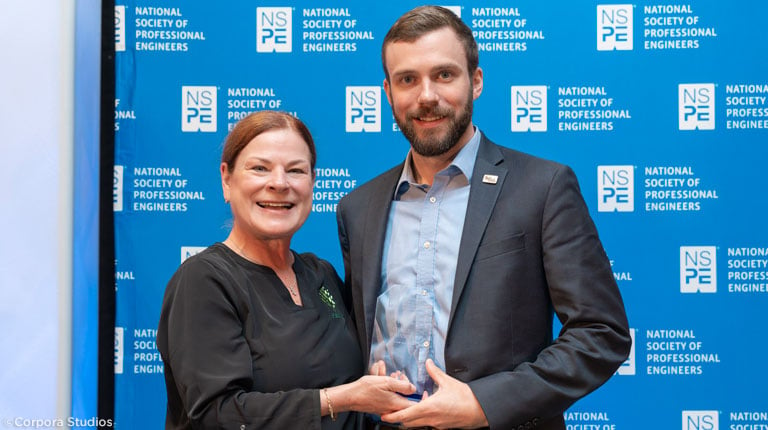 Charlie standing with the City of Raleigh Mayor Mary-Ann Baldin with his award.