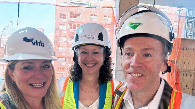 People smiling in construction hats.