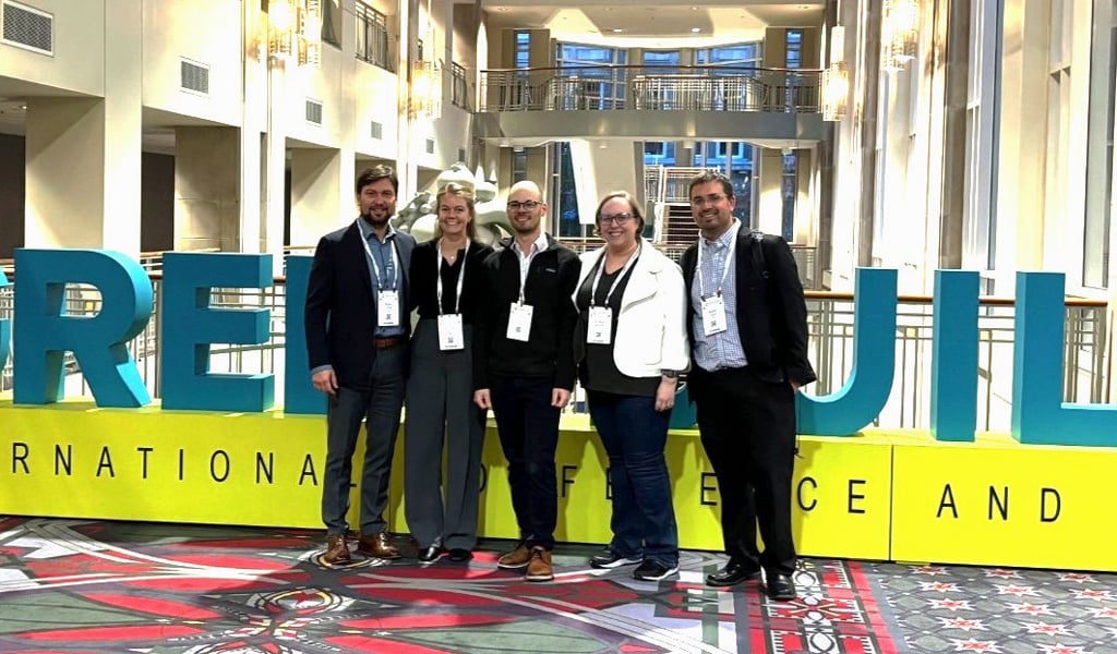 Five VHB employees standing in front of a large Greenbuild sign.