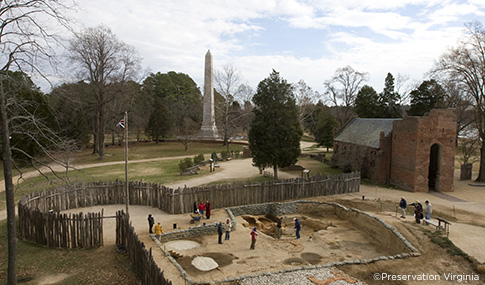 An aerial view of historic Jamestown that shows visitors observing the archaeology dig site.