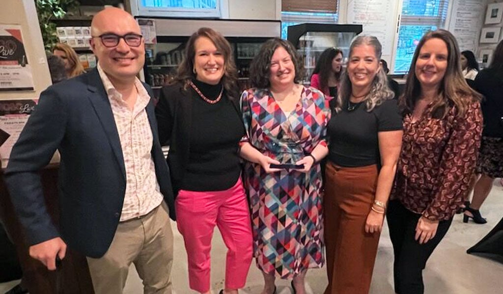 Four people stand with Jen McGovern for a group photo. 