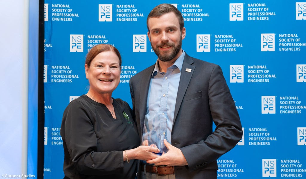 Charlie standing with the City of Raleigh Mayor Mary-Ann Baldin with his award.