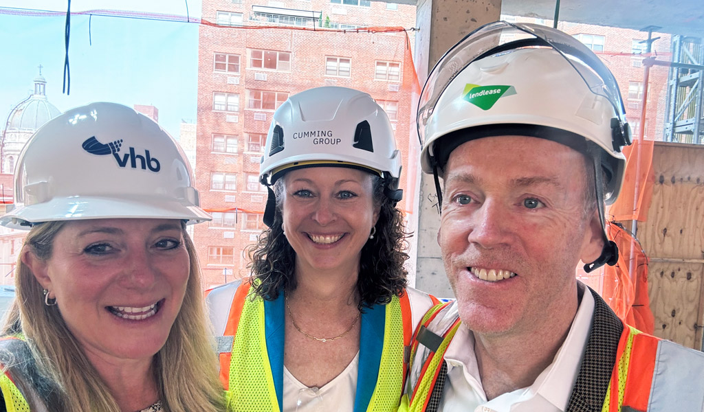 People smiling in construction hats.