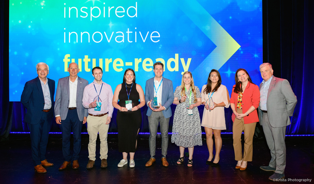 Group shot of the 2023 Rising Young Professionals of the Year RISE Award winners on stage and smiling in front of the words innovative and future-ready on the screen.