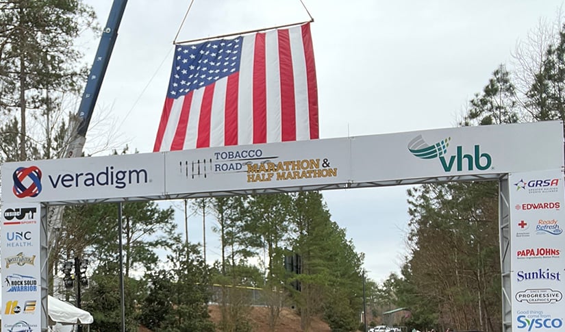 The Tobacco Road Half Marathon finish line with VHB’s logo on display.