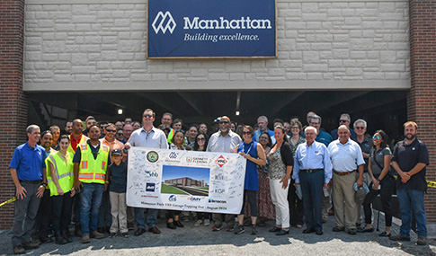 Team members gather for a group shot at the entrance of the garage.