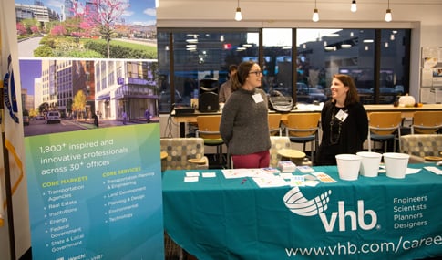 VHB team members stand at the company’s exhibit booth during an open house